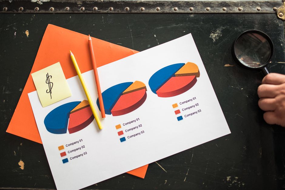 Operations manager comparing ERP dashboard data with spreadsheets and handwritten notes in a realistic office setting