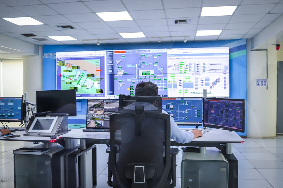 CTO and operations leaders reviewing enterprise systems dashboard in modern office with deep blue and gold professional lighting